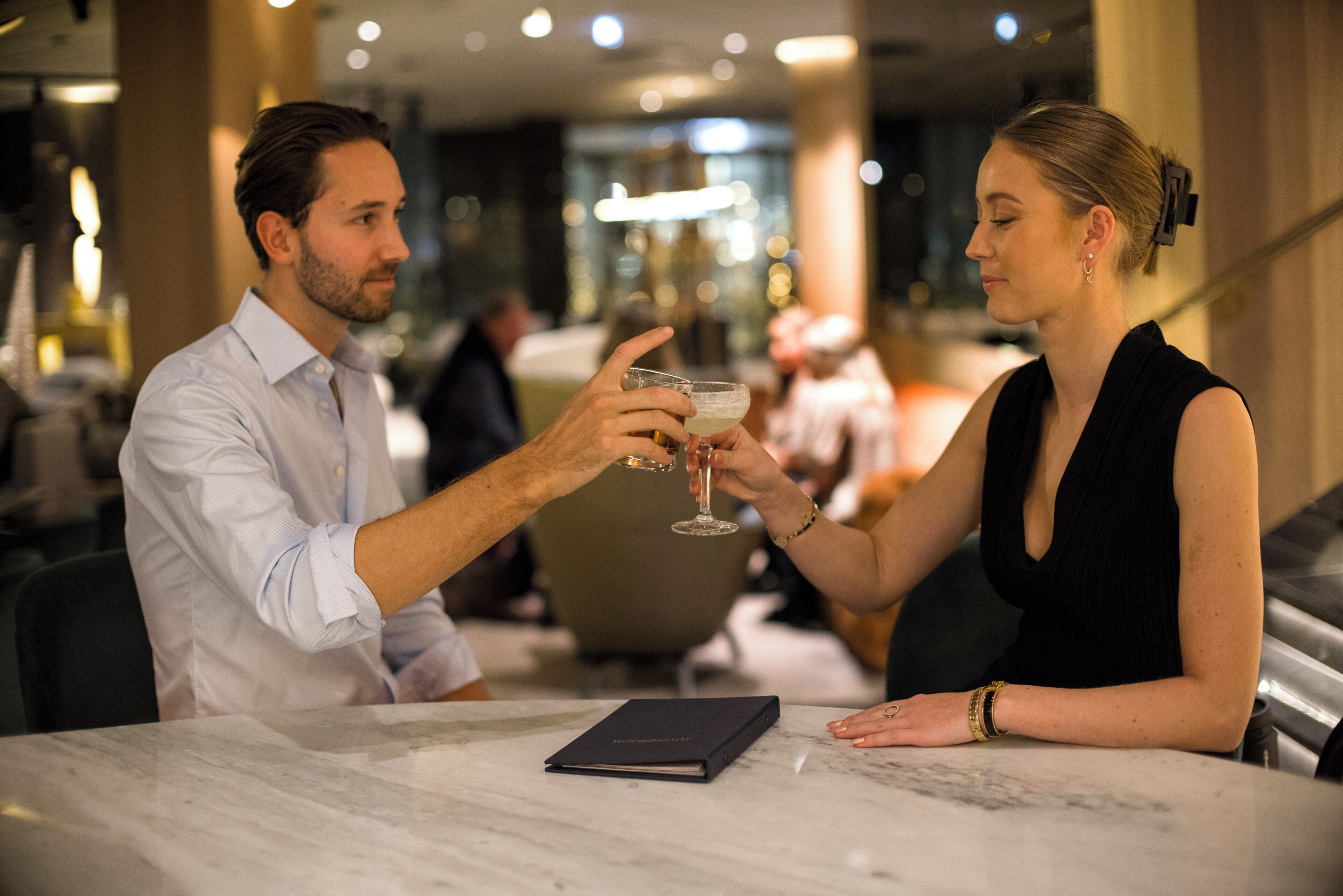 Two people at a table with a menu, in a well-lit indoor setting.