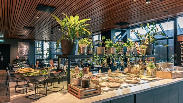 A buffet area with various food items, plants, and utensils. - Quality Hotel 11 (Gothenburg)