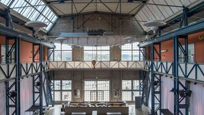 A spacious industrial-style interior with high ceilings, large windows, and exposed structural beams. - Quality Hotel 11 (Gothenburg)