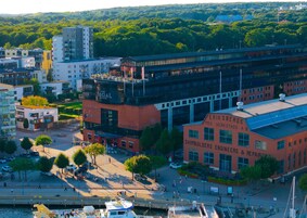 Un hotel moderno con un edificio rojo destacado que dice "Eriksbergs Mek. Verkstad A.B." y "Constructores e Ingenieros Navales, Reparaciones".
