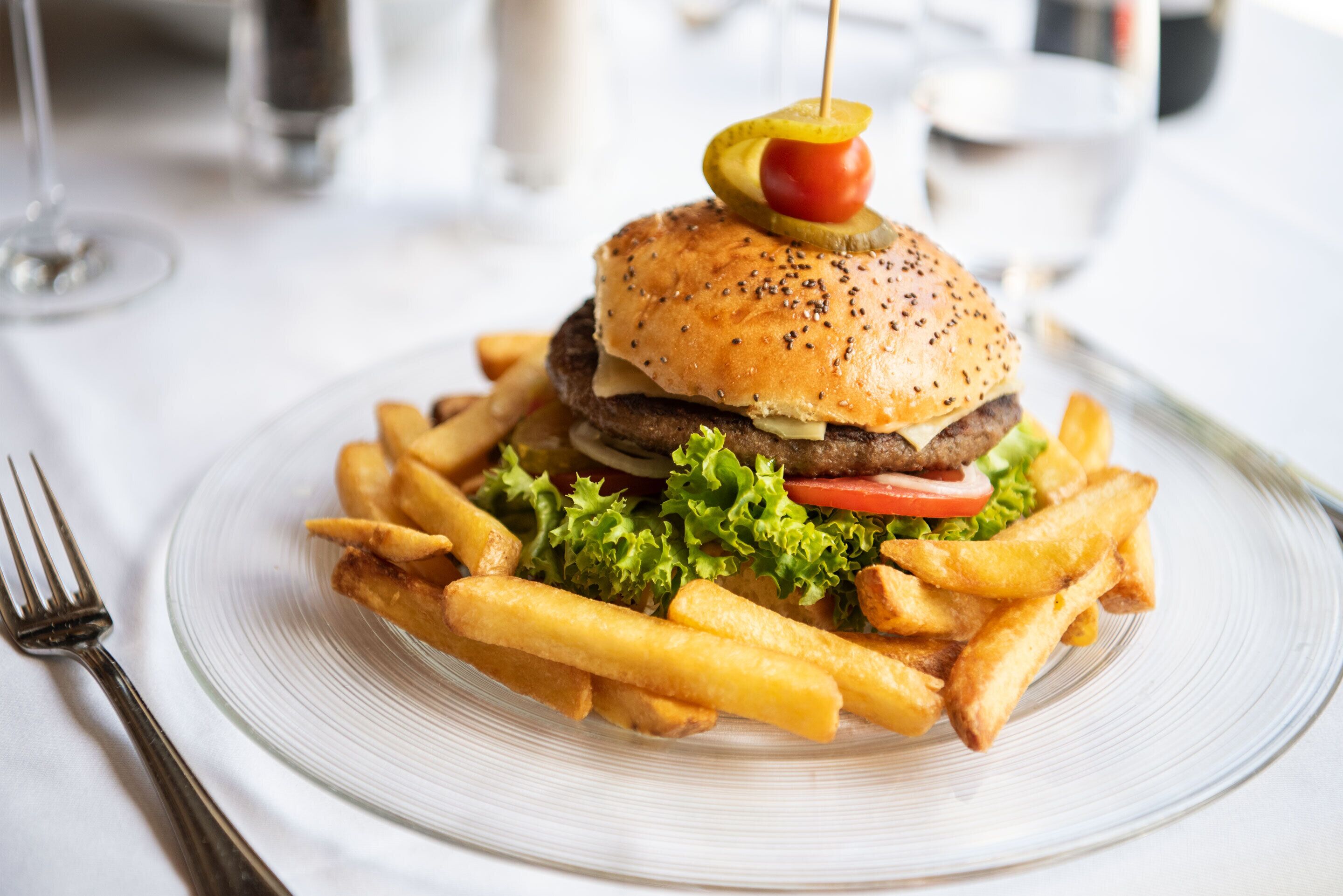 A burger with fries on a plate.
