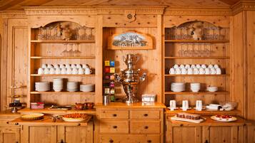 Un interior de madera con estantes llenos de tazas y platillos blancos, un juego de té, y un letrero que dice 'Tea Time'.