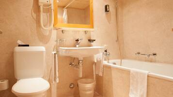 A bathroom with a toilet, sink, and bathtub.