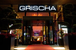 The entrance to a building with a prominent 'GRISCHA' sign. - Grischa - DAS Hotel Davos (Davos)