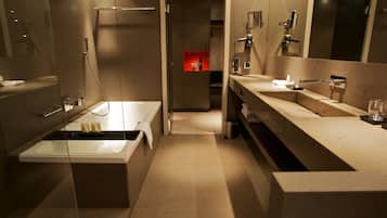 Un baño moderno con ducha de vidrio, tocador doble y espejo sobre el lavabo.