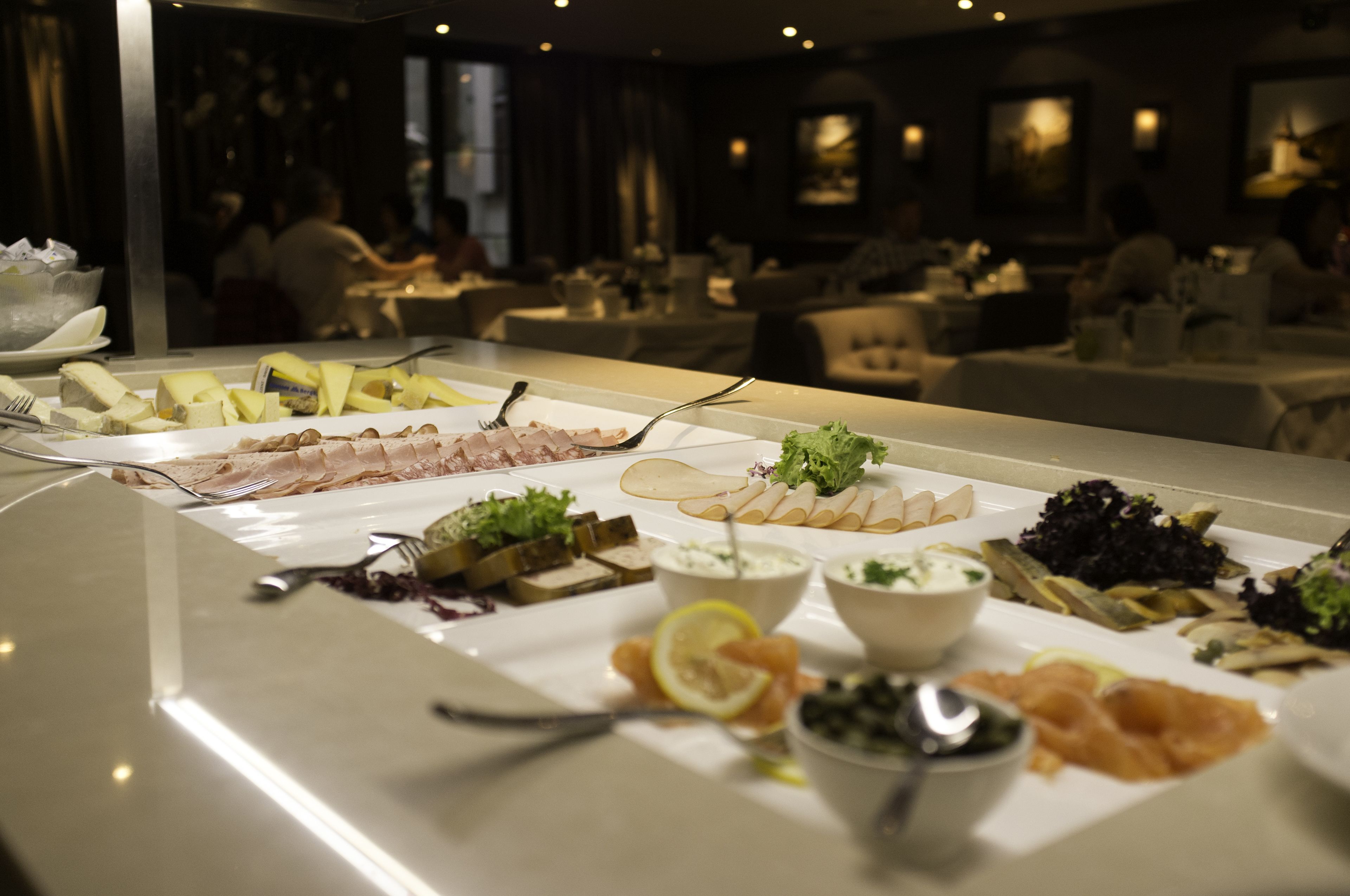 En buffet med et udvalg af madretter og et spiseområde i baggrunden.