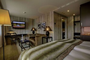 A hotel room with a bed, desk, chair, and TV. - Grischa - DAS Hotel Davos (Davos)