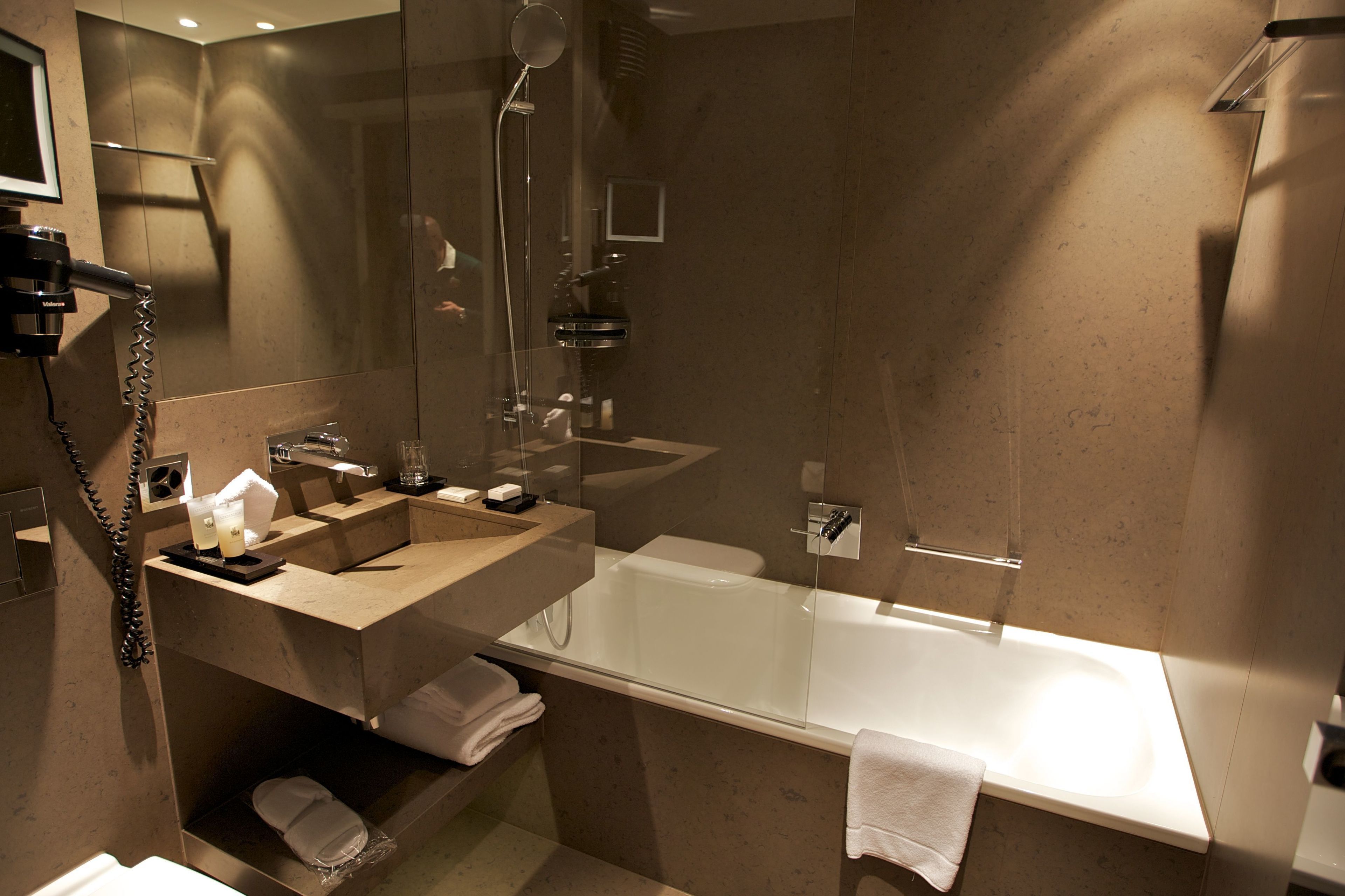 Une salle de bain moderne avec une douche à parois de verre, une grande baignoire et un meuble-lavabo avec un miroir.
