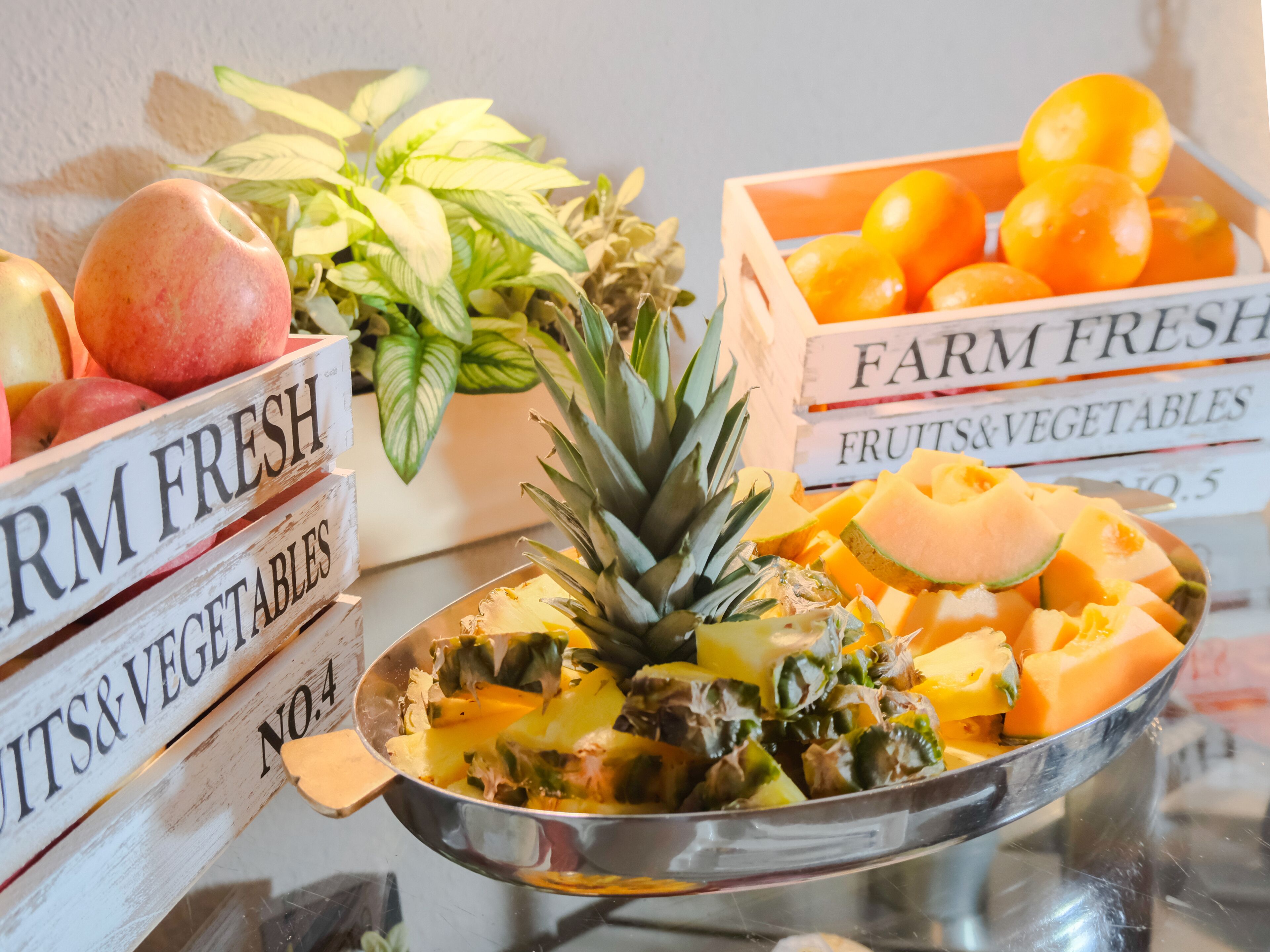 A display of fresh fruits and vegetables including apples, bananas, pineapples, and oranges.