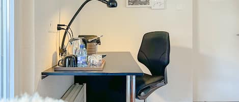 Un espacio de oficina pequeño y moderno con un escritorio, una silla y diversos útiles de oficina.