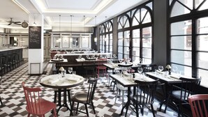 Un restaurante con suelo a cuadros, varias mesas y sillas.