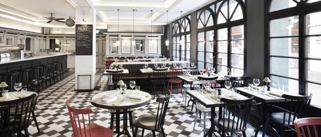 A restaurant with a checkered floor, multiple dining tables, and chairs.