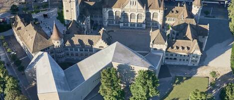 An aerial view of a historic building complex with multiple towers and a large central structure.