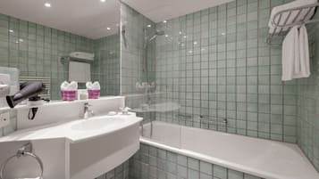 A bathroom with a large sink, a shower, and a glass-enclosed bathtub.