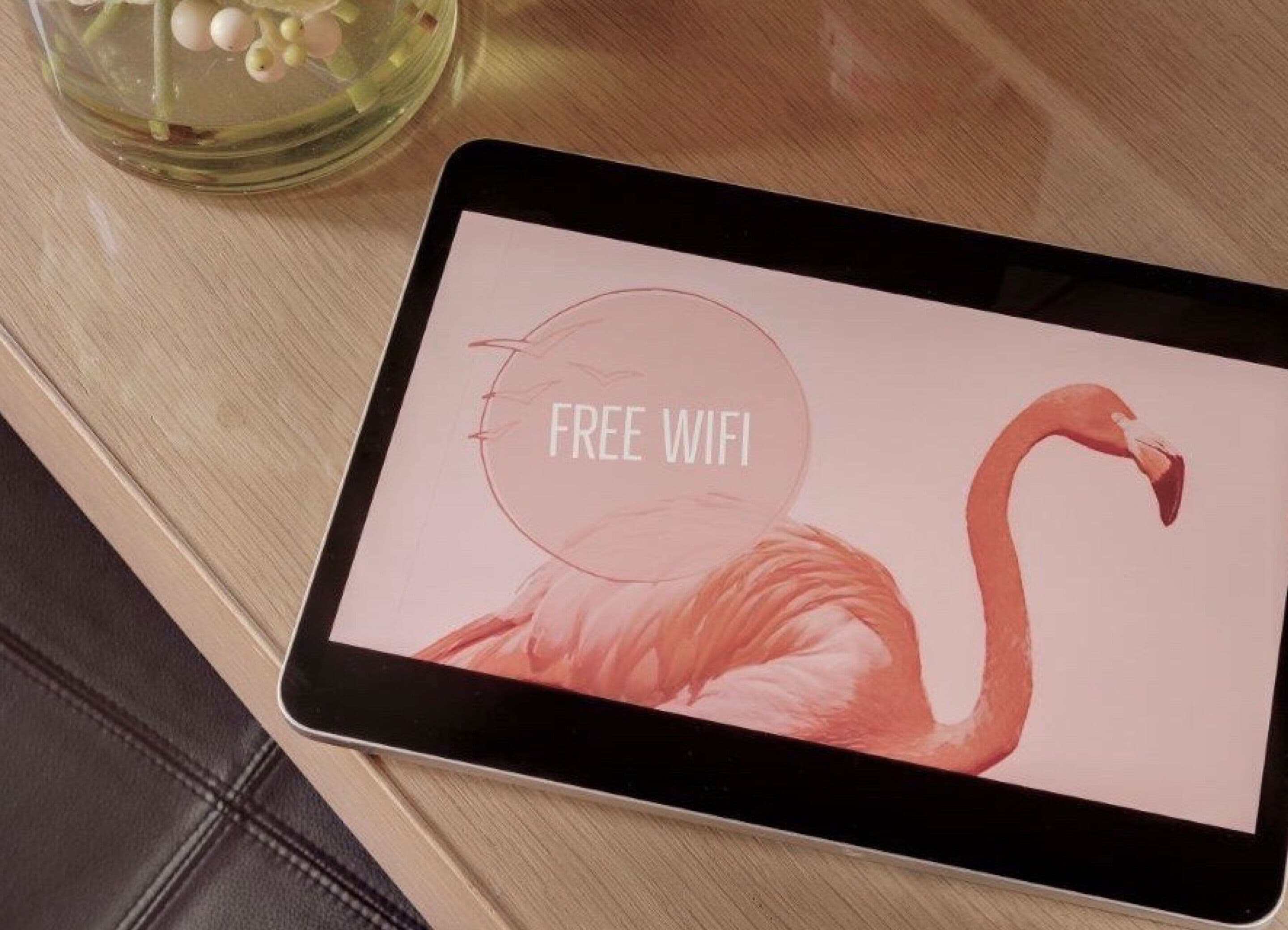 A tablet displaying "FREE WIFI" with a flamingo graphic.