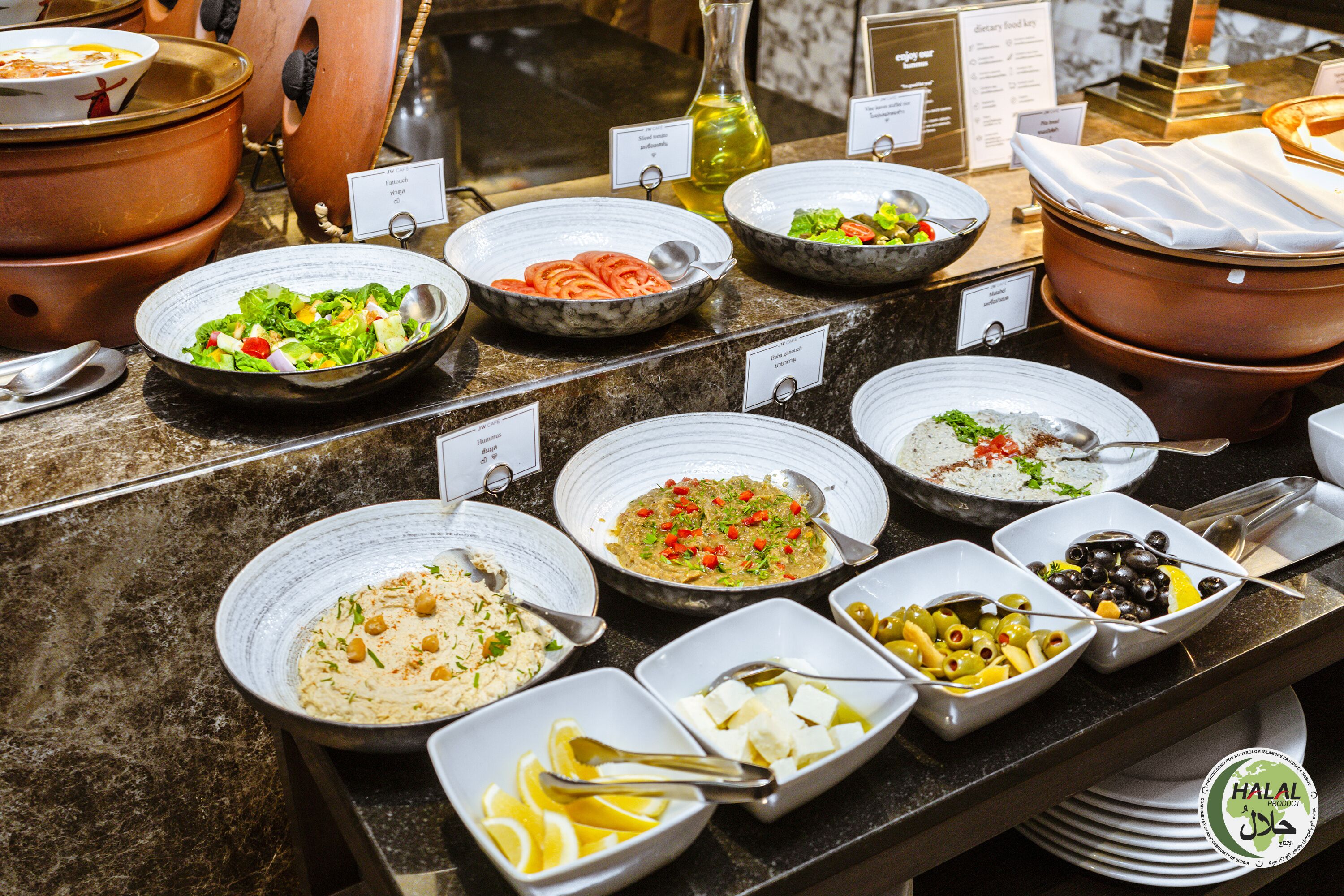 Un bufé con diversos platos, como ensaladas, arroz y pasta.