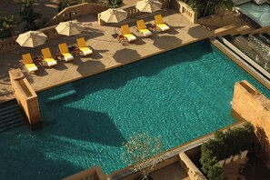 A large rectangular pool with clear blue water, surrounded by sun loungers and umbrellas. - Dusit Princess Srinakarin (Bangkok)