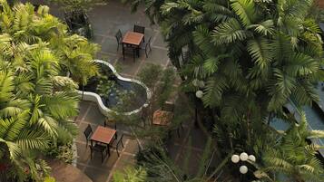 Un jardín en la azotea con zonas de estar y exuberante vegetación tropical.