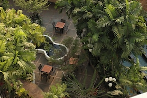 A rooftop garden with seating areas and lush tropical plants.