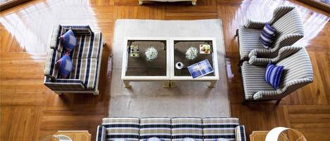 Un salón amplio con un conjunto de sofás, una mesa de centro y dos sillones.