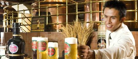 A bar with copper brewing equipment and bottles of beer.