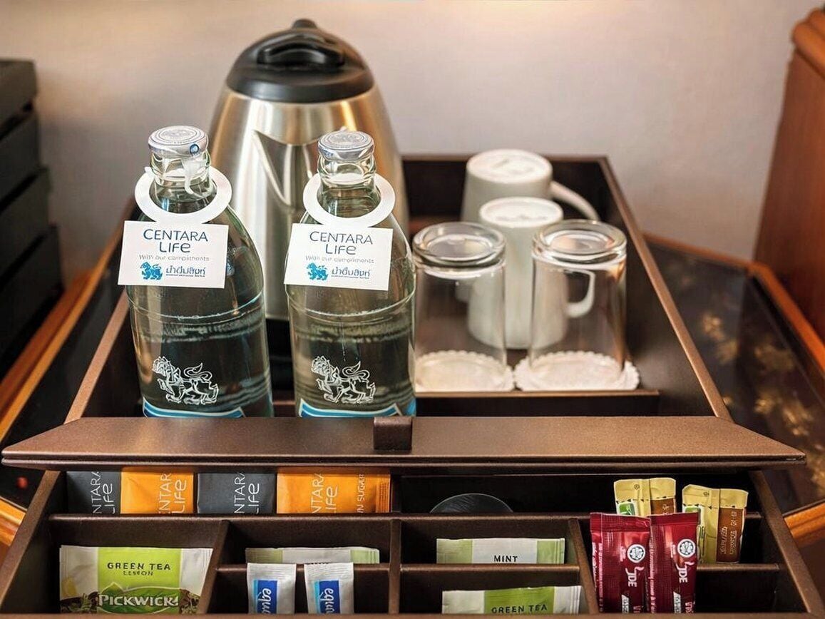 A coffee station with Centara Life tea bottles, a coffee maker, and various tea packets.