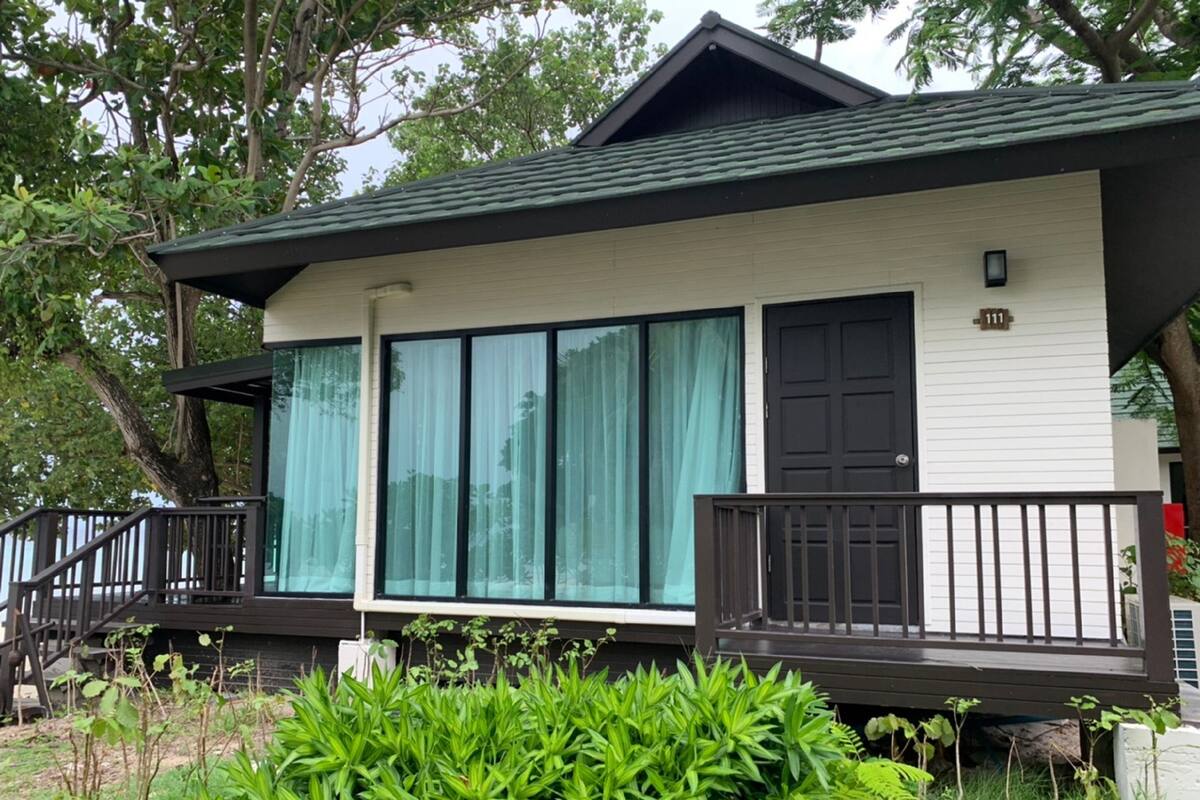 Une maison à deux étages avec un balcon, de grandes fenêtres et une porte.