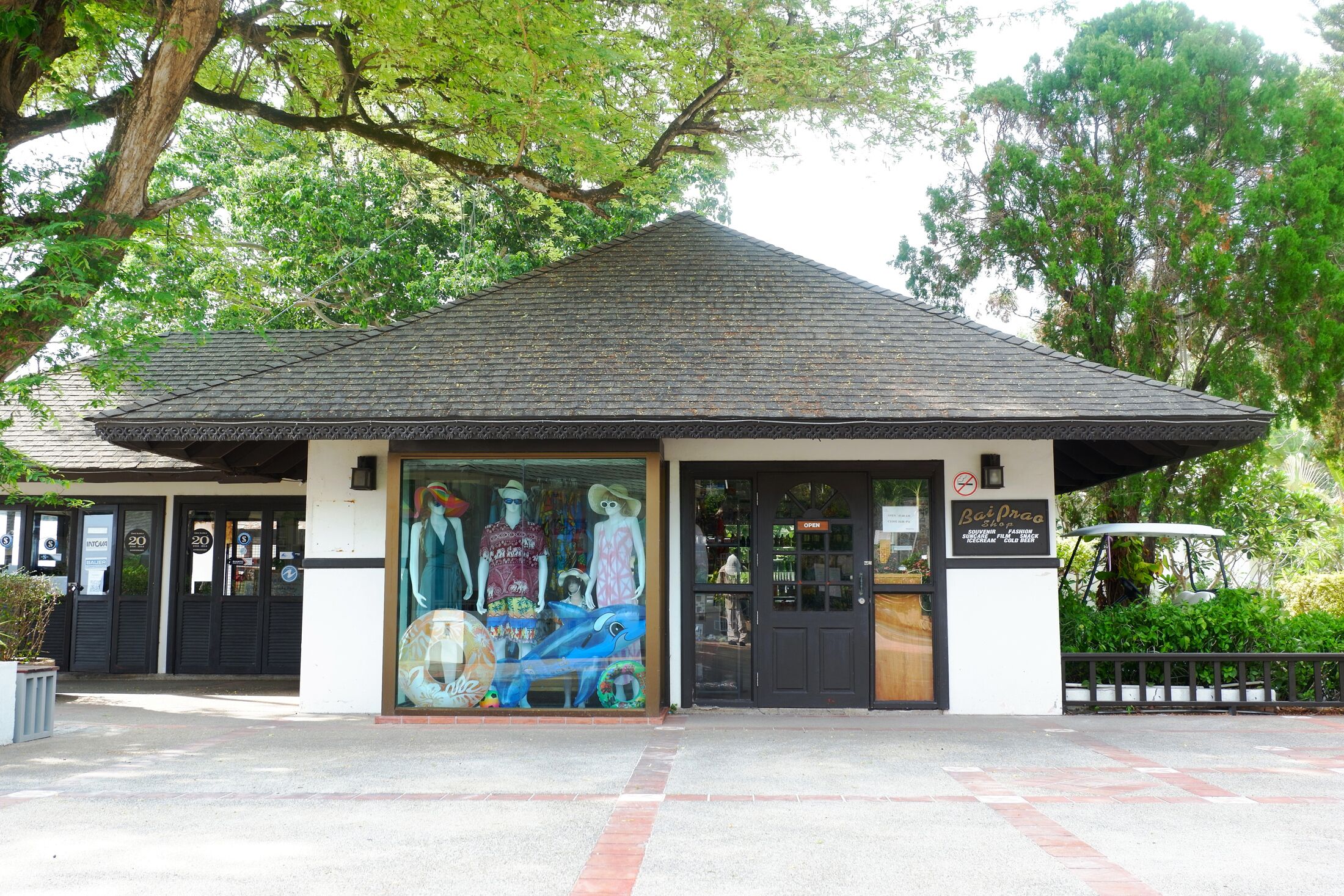 A building with a tiled roof, a storefront with mannequins, and a sign that reads "Bazar".