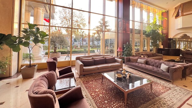 A spacious living room with large windows, comfortable seating, and a coffee table. - Eresin Hotels Topkapi (Istanbul)