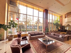 Un salón amplio con ventanas grandes, asientos cómodos y una mesa de centro.