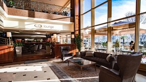 A lounge area with a bar, seating, and large windows offering a view of the outside. - Eresin Hotels Topkapi (Istanbul)