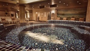 A large indoor swimming pool with mosaic tiles, surrounded by lounge chairs and a seating area with tables and chairs. - Eresin Hotels Topkapi (Istanbul)