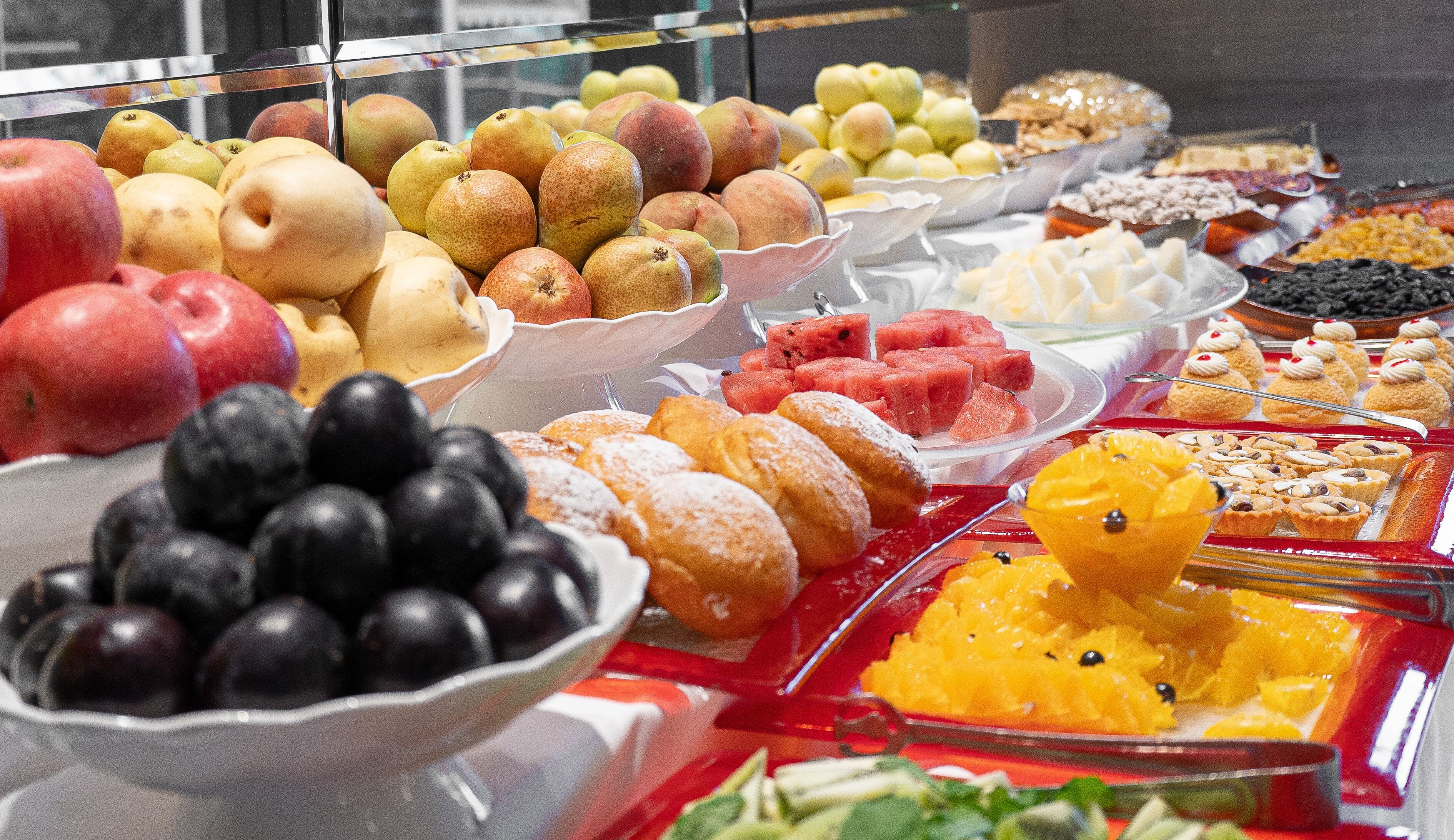 A buffet with various fruits and pastries.