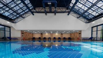 An indoor swimming pool with a high ceiling and skylights.