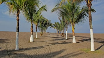 On the beach, black sand, sun-loungers, beach towels