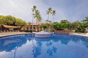 A clear blue swimming pool with a central island, surrounded by palm trees and a building with balconies. - Best Western Jaco Beach All-Inclusive Resort (Jacó)