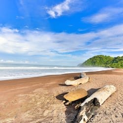 On the beach, black sand, sun loungers, beach towels