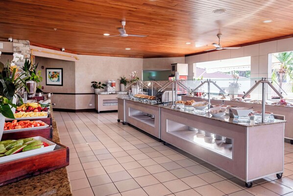 A buffet area with various food options, a ceiling fan, and a view of the outside.