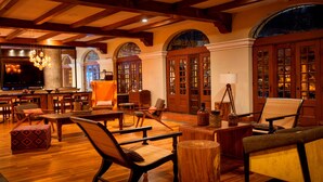 A spacious lobby with wooden flooring, comfortable seating, a television, and a fireplace. - Costa Rica Marriott Hotel Hacienda Belen (La Asunción)