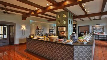 A breakfast bar with various food items and a coffee station.