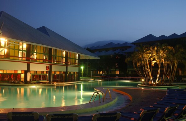 Una piscina al aire libre, sombrillas, tumbonas