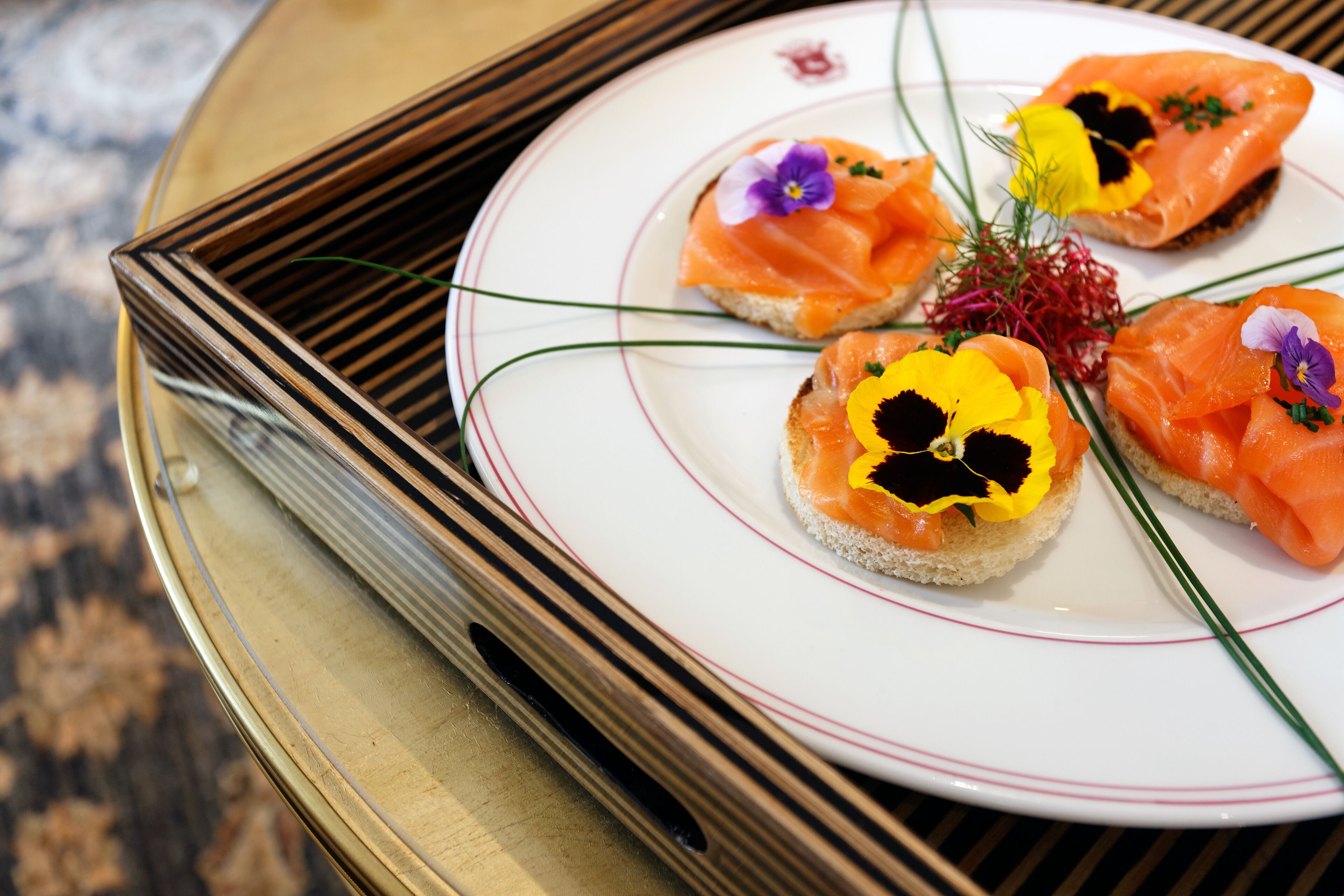 A plate with three pieces of food garnished with flowers.