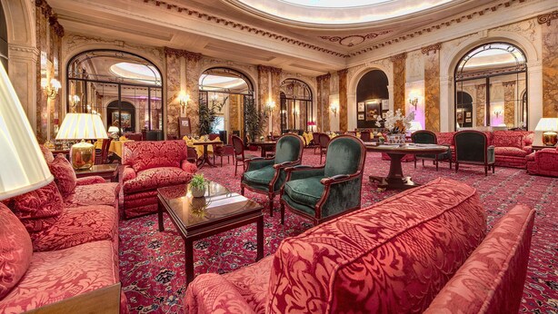 Een luxe lobby met versierde architectuur, comfortabele zitplaatsen en stijlvolle inrichting.
