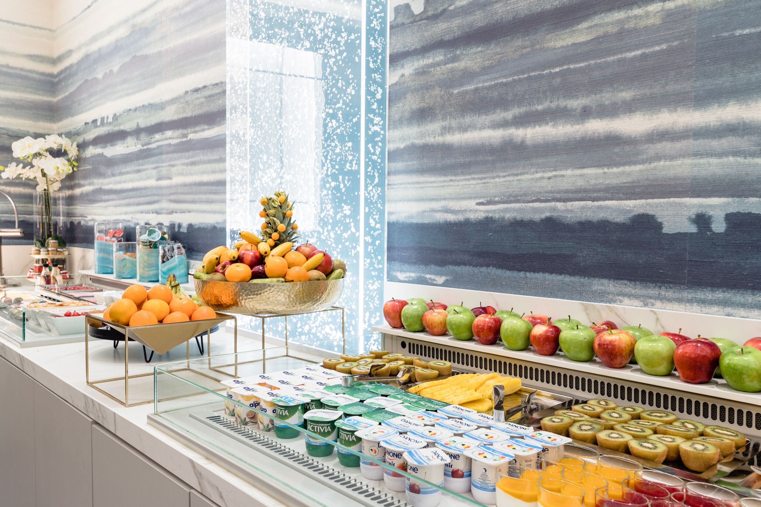 A buffet with various fruits, yogurt, and juices.
