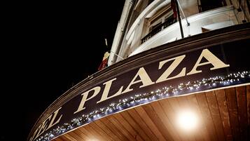 A sign with "PLAZA" written on it, surrounded by string lights.