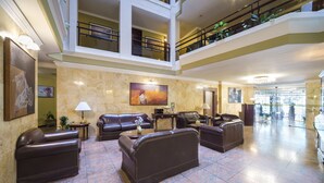 A spacious lobby with leather sofas, a coffee table, and a painting on the wall. - Ritz Apart Hotel (La Paz)