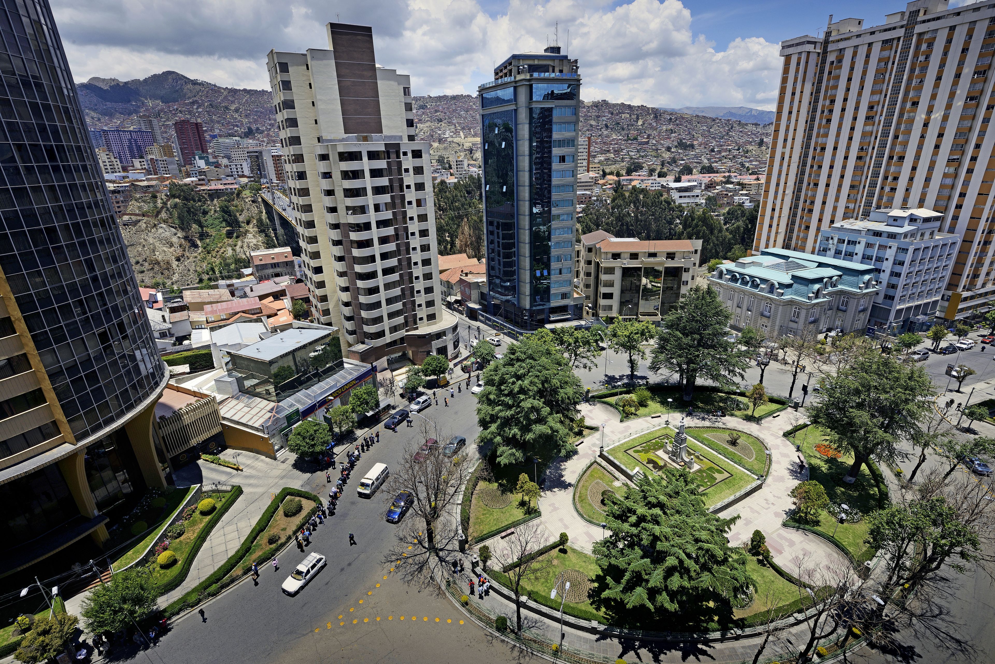 A cityscape with modern high-rise buildings, a roundabout, and a park area.