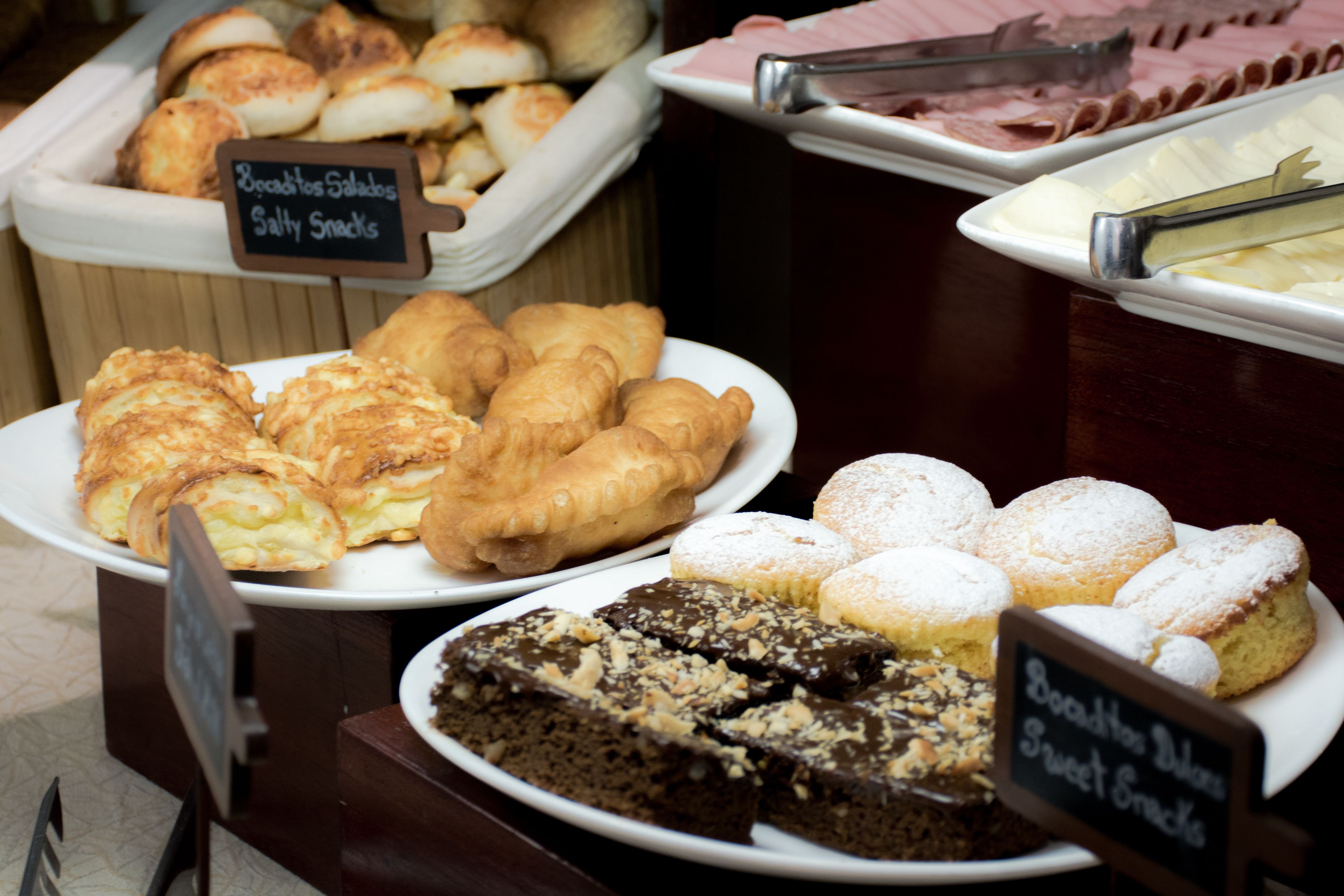 Un bufé con diversas opciones de panadería, incluyendo pasteles, pan y postres.