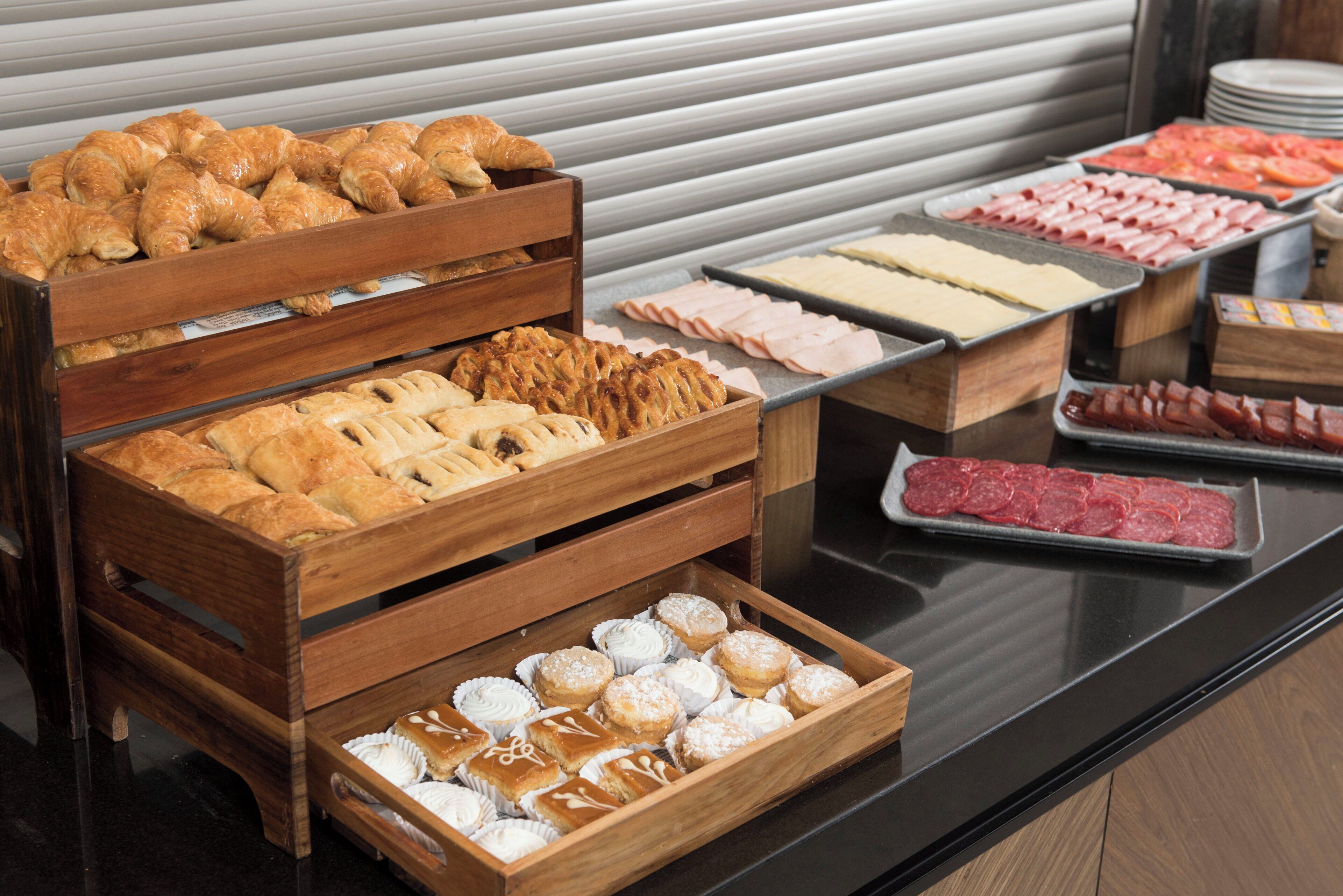 A buffet with various food items including pastries, meats, and desserts.