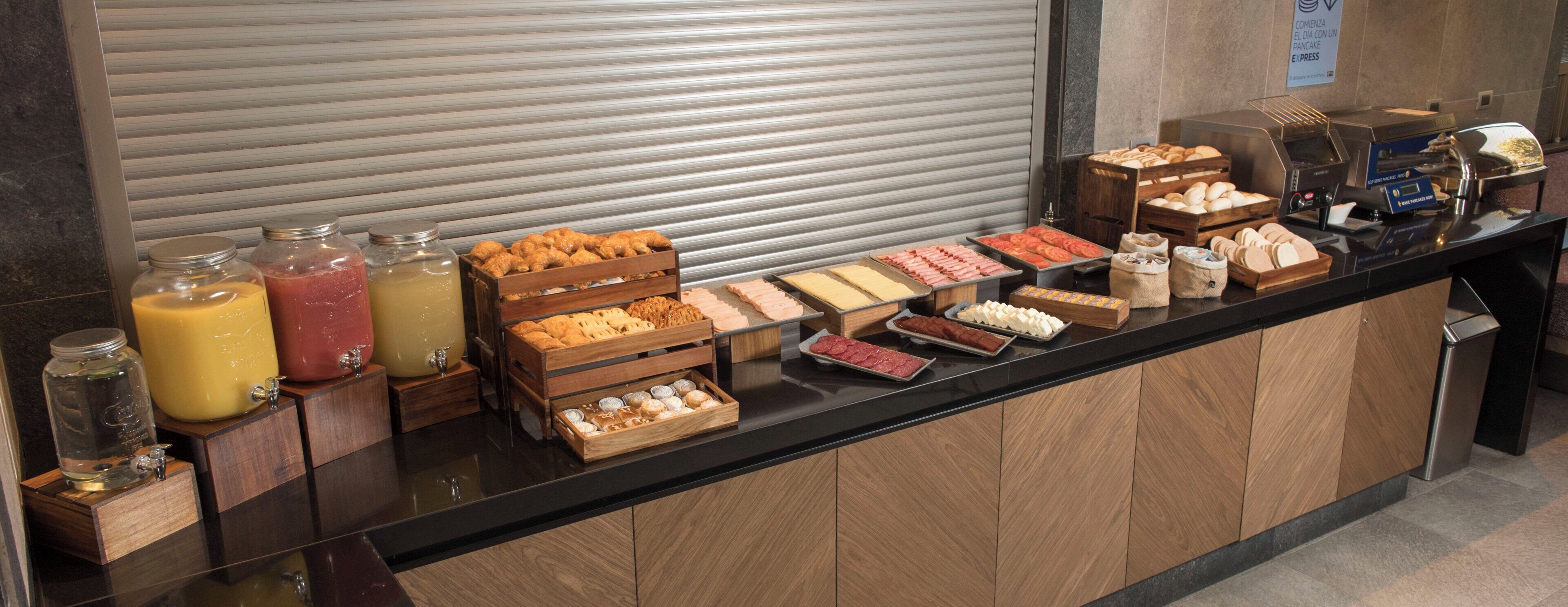 A buffet counter with various food items and beverages.